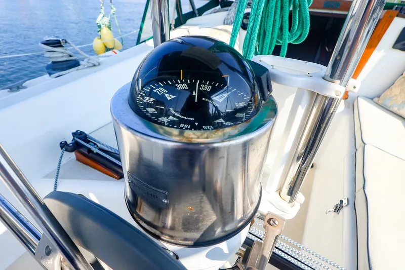 Slide: The Image of Compass on 1988 Tartan 34-2 sailboat, with ropes and nautical equipment in view. - 16