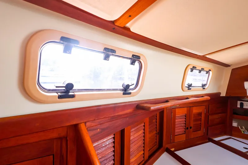 Slide: The Image of Interior of a 1988 Tartan 34-2 sailboat with wooden cabinetry and porthole windows. - 32