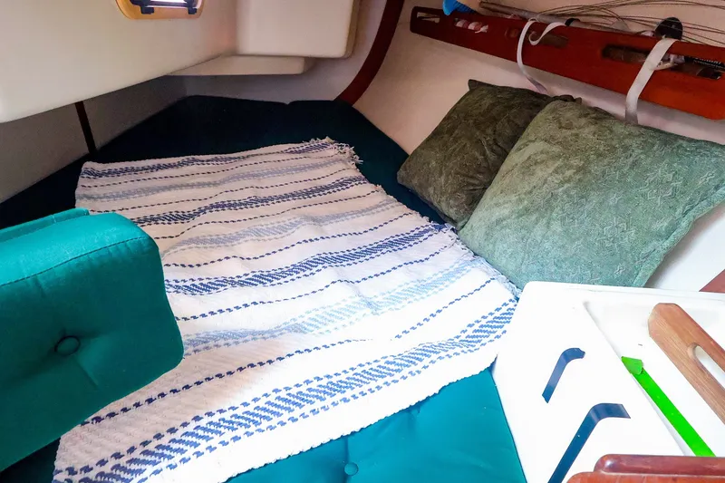 Slide: The Image of Cozy cabin interior of 1988 Tartan 34-2 sailboat with striped blanket and green cushions. - 37