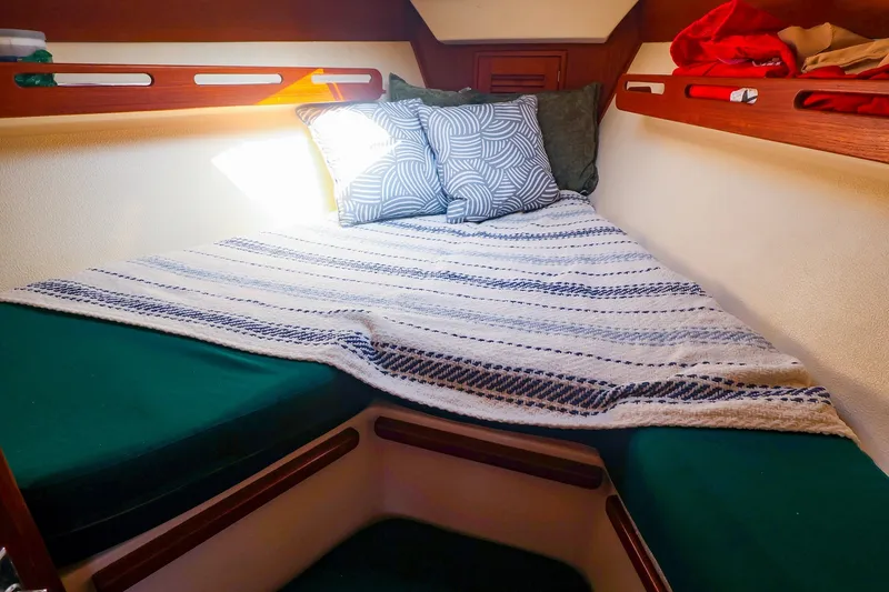 Slide: The Image of Cozy cabin interior of 1988 Tartan 34-2 sailboat with striped bedding and pillows. - 36