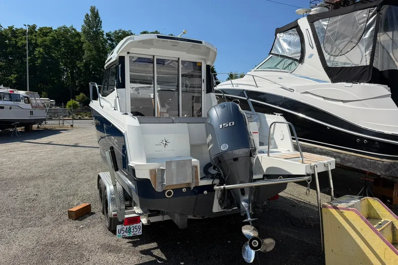 Slide: The Image of 2019 Jeanneau NC 695 boat with Yamaha 150 engine, parked on a trailer. - 13