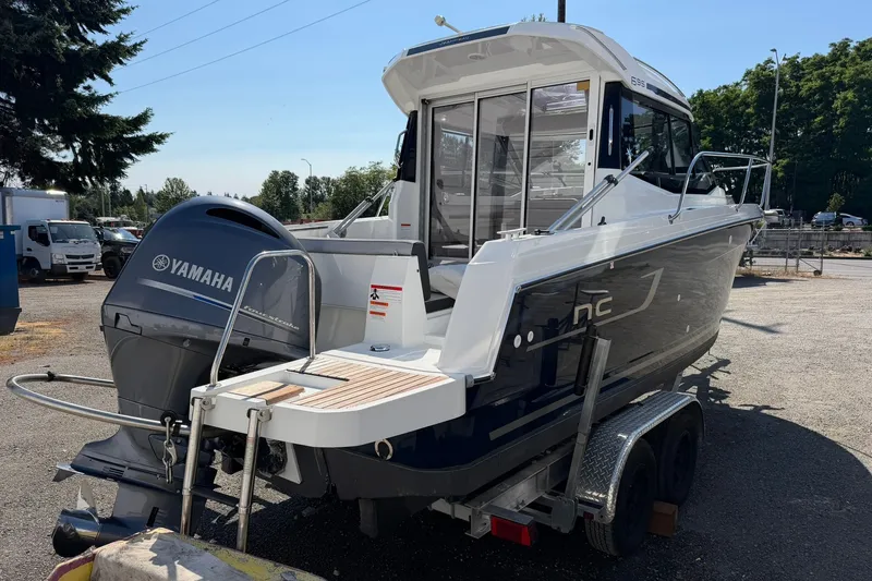 Slide: The Image of 2019 Jeanneau NC 695 boat on trailer with Yamaha outboard motor. - 14