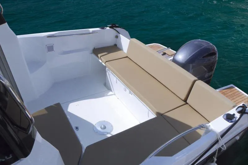 Slide: The Image of Manufacturer Provided Image: 2019 Jeanneau NC 695 boat with beige seating and outboard motor on clear water. - 7