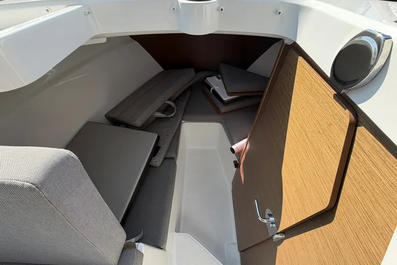 Slide: The Image of Interior cabin of 2019 Jeanneau NC 695 boat, featuring seating and wooden door. - 22