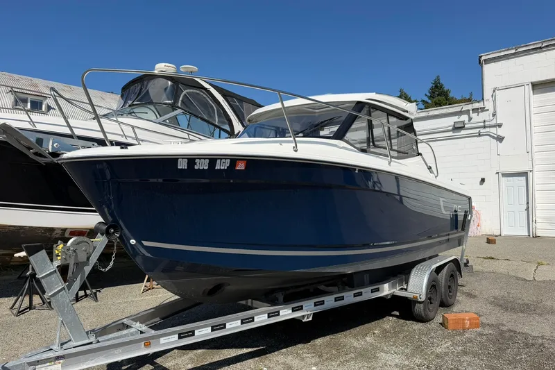 Slide: The Image of 2019 Jeanneau NC 695 boat on trailer, parked outdoors under clear blue sky. - 16