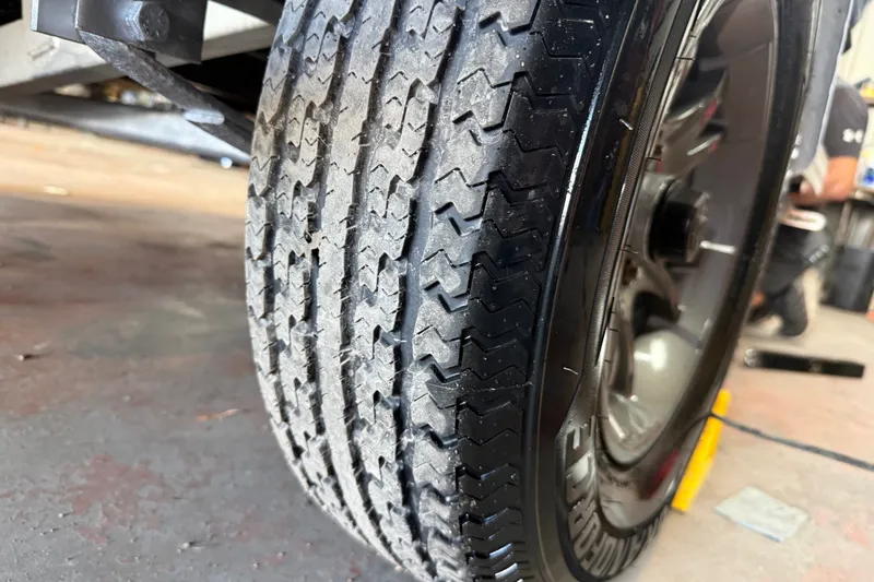 Slide: The Image of Close-up of a 2016 Xpress H18 Bay trailer tire in a workshop setting. - 13