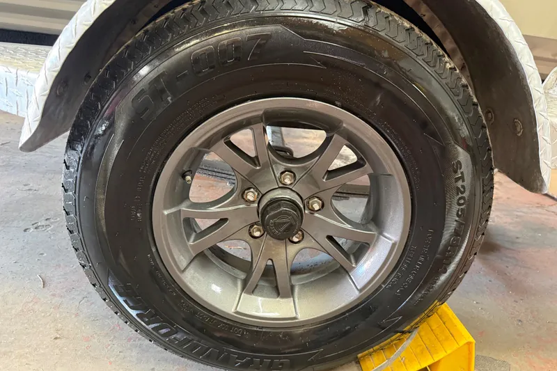 Slide: The Image of 2016 Xpress H18 Bay trailer tire with alloy wheel on a yellow ramp. - 12