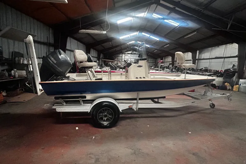 Slide: The Image of 2016 Xpress H18 Bay boat in a warehouse, featuring a Yamaha outboard motor. - 3
