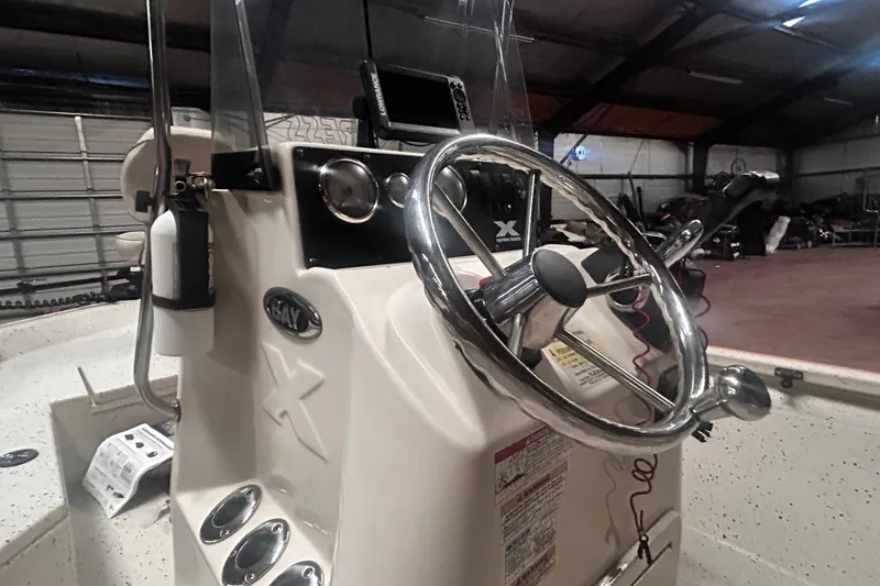 Slide: The Image of 2016 Xpress H18 Bay boat console with steering wheel and controls in a garage setting. - 22
