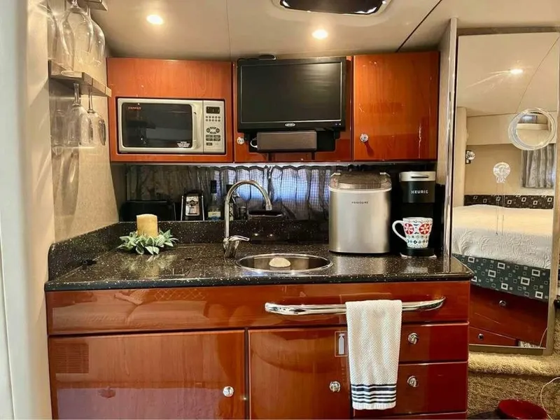 Slide: The Image of The galley of a 2006 Formula 31 Performance Cruiser with wood cabinets, sink, microwave, and coffee maker. - 16