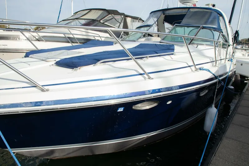 Slide: The Image of A 2006 Formula 31 Performance Cruiser docked at a marina. It features a blue and white design. - 2