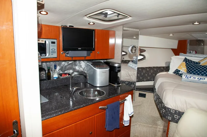Slide: The Image of The interior cabin of a 2006 Formula 31 Performance Cruiser features a kitchenette with sink and microwave. - 15