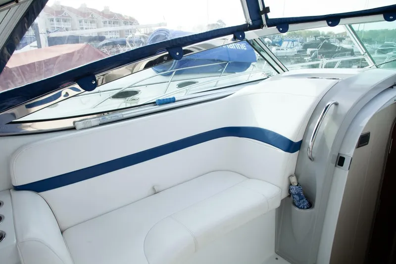 Slide: The Image of Interior view of a boat with white and blue upholstery, harbor visible in the background. - 28