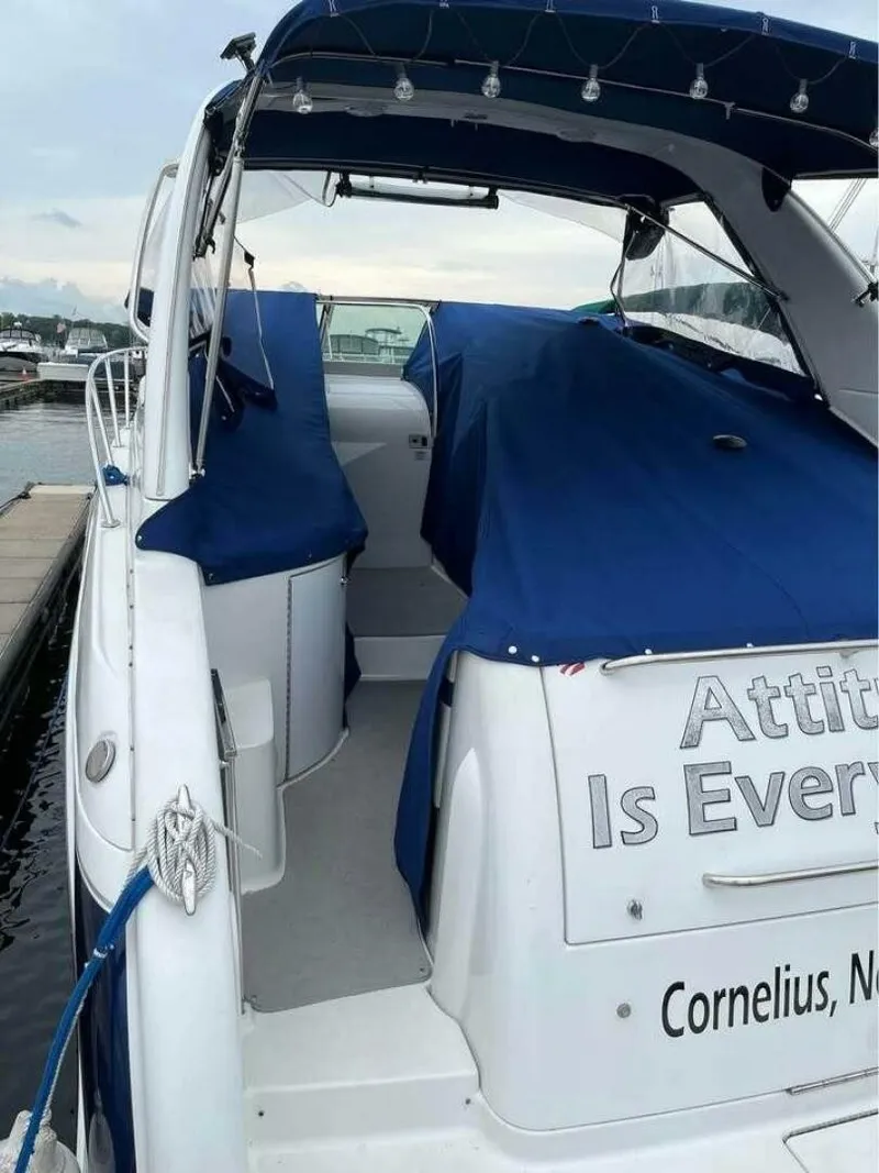 Slide: The Image of A white motor yacht with blue covers docked. The name "Attitude Is Everything" is visible. - 4