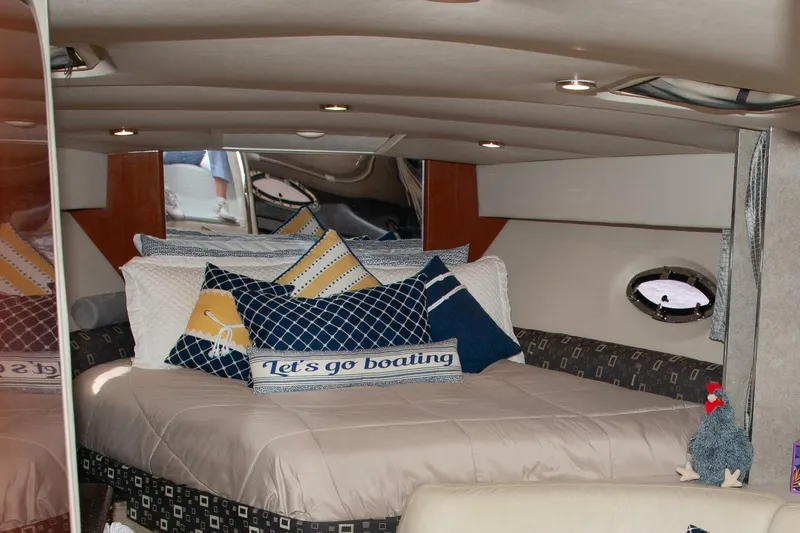 Slide: The Image of The interior of a 2006 Formula 31 Performance Cruiser features a cozy bed with decorative pillows. - 19
