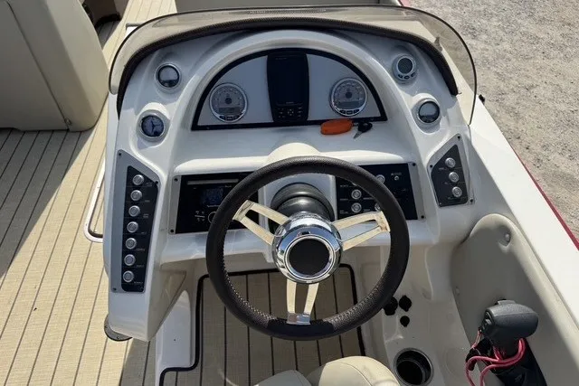 Slide: The Image of Cockpit view of a 2018 Larson Escape 23 Triple TTT boat with steering wheel and controls. - 13