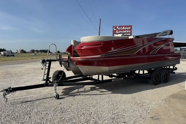 Slide: The Image of Red 2018 Larson Escape 23 Triple TTT boat on trailer at outdoor dealership. - 5