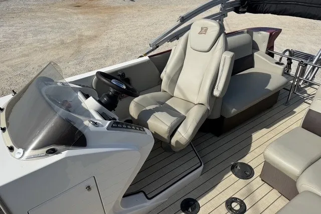 Slide: The Image of 2018 Larson Escape 23 Triple TTT boat interior with beige seating and modern dashboard. - 6