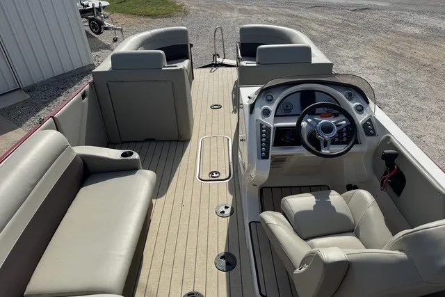 Slide: The Image of 2018 Larson Escape 23 Triple TTT boat interior with beige seating and modern dashboard. - 10