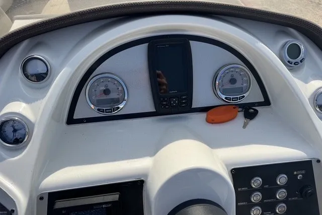 Slide: The Image of Dashboard of a 2018 Larson Escape 23 Triple TTT boat with gauges and controls. - 11