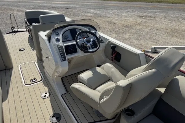 Slide: The Image of 2018 Larson Escape 23 Triple TTT boat interior with steering console and seating. - 7