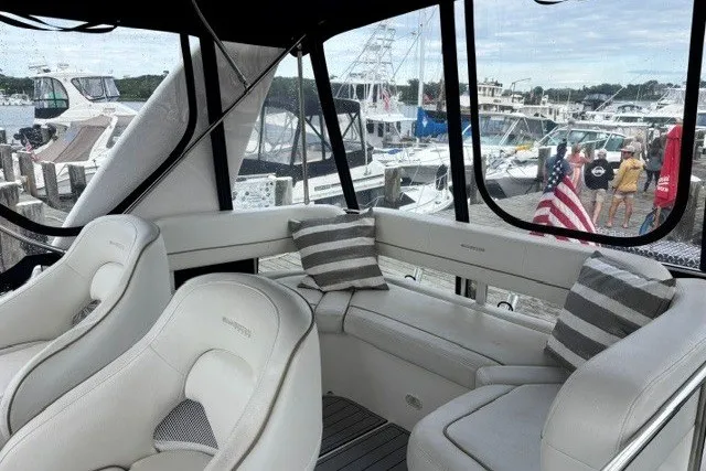 Slide: The Image of Interior of 2006 Silverton 34 Convertible yacht with plush seating and marina view. - 20
