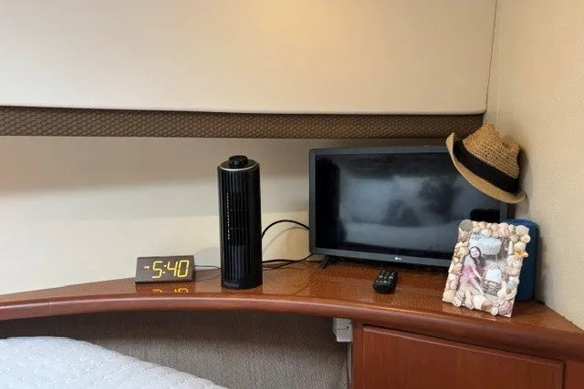 Slide: The Image of Interior of 2006 Silverton 34 Convertible with TV, clock, and decorative items on a wooden shelf. - 17