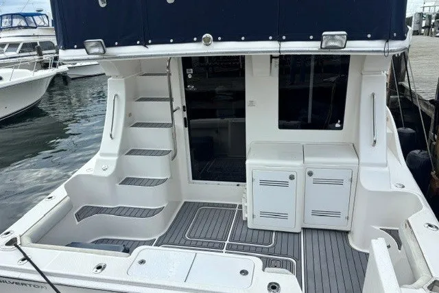 Slide: The Image of 2006 Silverton 34 Convertible yacht with spacious deck and modern amenities at a marina. - 3
