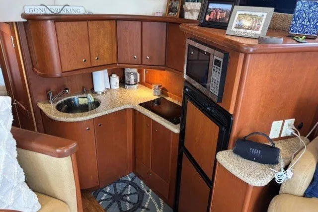 Slide: The Image of 2006 Silverton 34 Convertible yacht kitchen with wood cabinetry and modern appliances. - 11