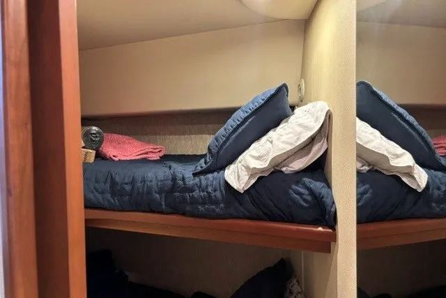 Slide: The Image of Bunk beds in 2006 Silverton 34 Convertible yacht cabin with blue bedding and pillows. - 19