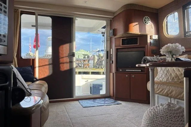 Slide: The Image of Interior of 2006 Silverton 34 Convertible yacht, featuring cozy seating and entertainment area. - 8