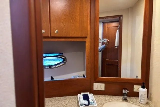 Slide: The Image of Bathroom interior of 2006 Silverton 34 Convertible yacht with wooden cabinetry and porthole window. - 12