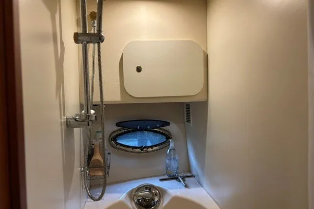 Slide: The Image of 2006 Silverton 34 Convertible yacht bathroom with shower and porthole window. - 14