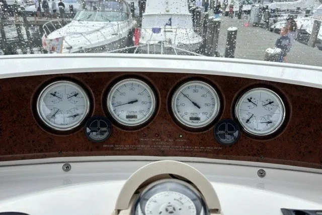 Slide: The Image of Dashboard of a 2006 Silverton 34 Convertible boat with gauges and marina view. - 23