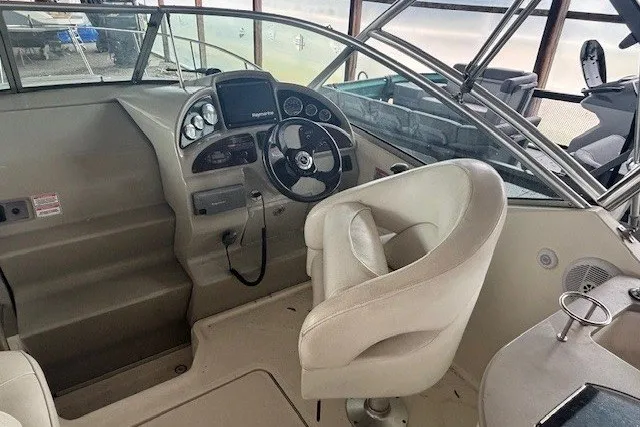 Slide: The Image of 2005 Sea Ray 270 Amberjack boat cockpit with steering wheel and navigation controls. - 6
