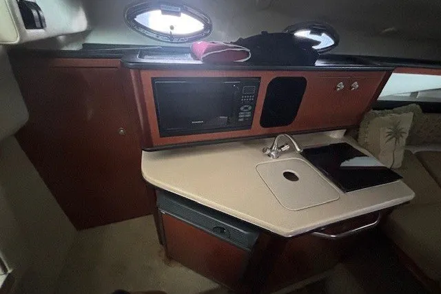 Slide: The Image of 2005 Sea Ray 270 Amberjack cabin interior with kitchenette, microwave, and sink. - 10