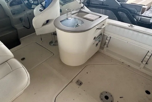 Slide: The Image of 2005 Sea Ray 270 Amberjack interior with helm, seating, and compact kitchenette. - 7