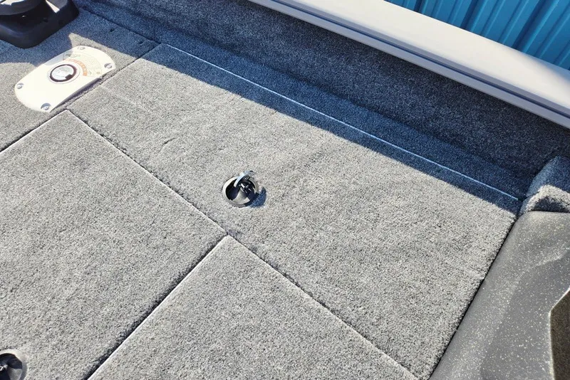 Slide: The Image of 2027 Tracker Pro Team 175 Crappie Edition boat deck with gray carpet and storage compartment. - 27