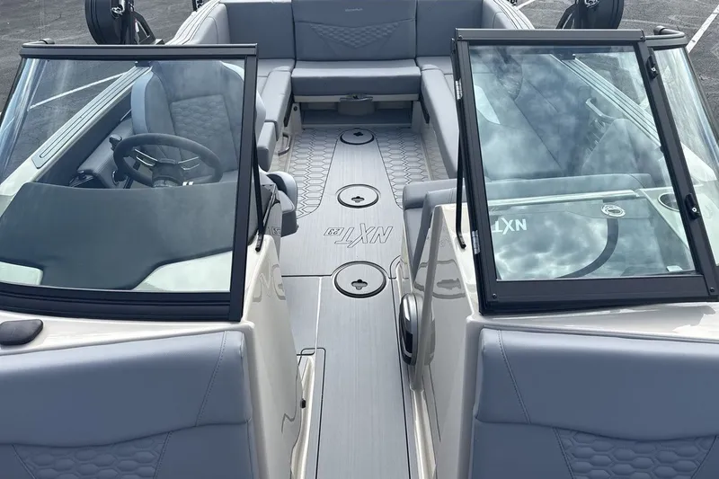 Slide: The Image of The image shows the interior of a 2027 MasterCraft NXT23 boat with gray upholstery and modern fittings. - 12