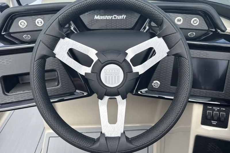 Slide: The Image of The image shows the steering wheel of a 2027 MasterCraft NXT23 boat with modern controls. - 14