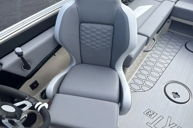 Slide: The Image of The interior of a 2027 MasterCraft NXT23 features a gray captain's chair and modern dashboard. - 13