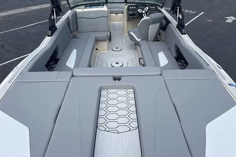 Slide: The Image of The image shows the interior of a 2027 MasterCraft NXT23 boat with gray upholstery. - 9