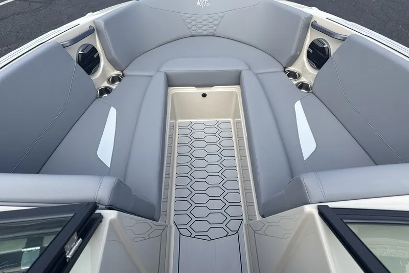 Slide: The Image of The image shows the bow area of a MasterCraft NXT23 boat with gray upholstery and a textured floor. - 11