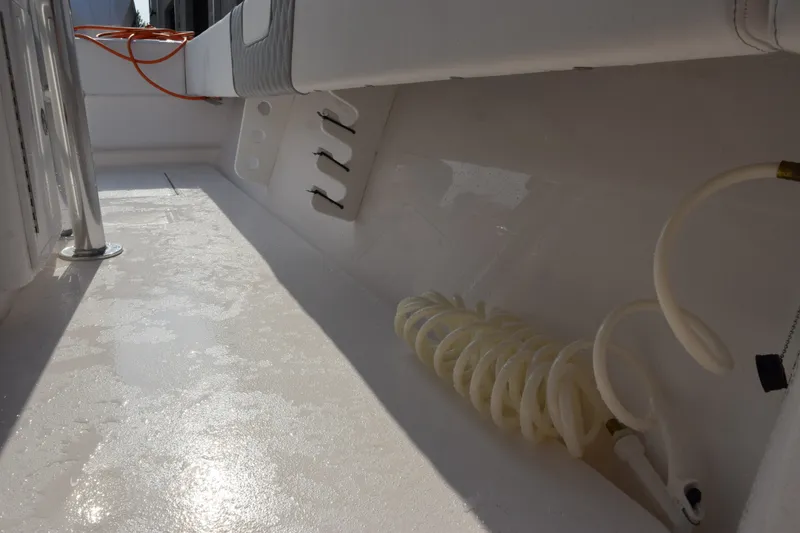 Slide: The Image of Interior view of 2027 Contender 44 ST boat, featuring coiled hose and clean deck. - 26