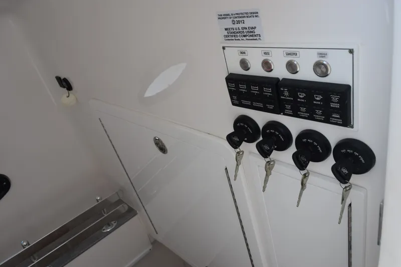 Slide: The Image of Control panel of a 2027 Contender 44 ST boat with ignition keys and switches. - 28