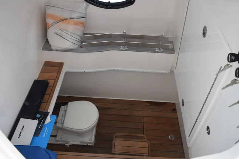 Slide: The Image of 2027 Contender 44 ST boat interior with wooden flooring and compact toilet area. - 27