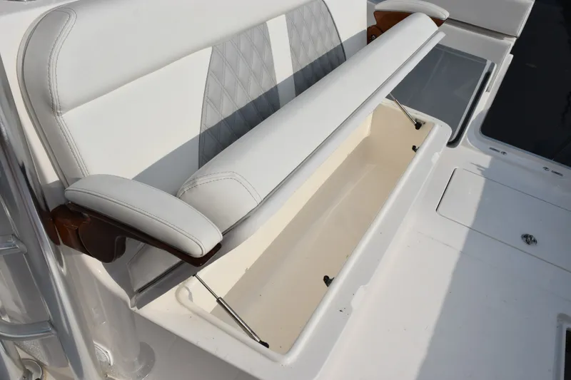 Slide: The Image of 2027 Contender 44 ST boat seat with storage compartment open. - 48