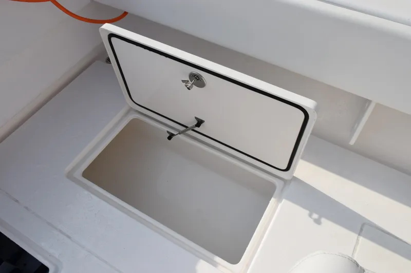 Slide: The Image of Open storage compartment on 2027 Contender 44 ST boat, featuring a secure latch. - 49