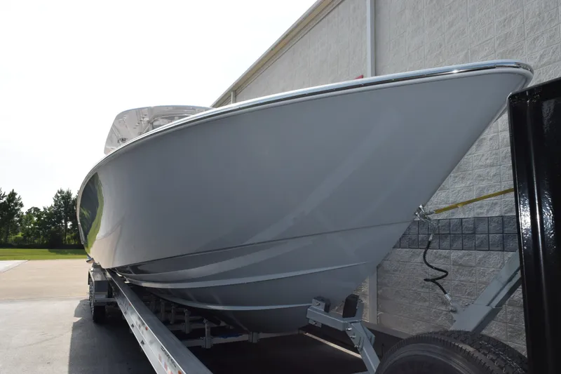 Slide: The Image of 2027 Contender 44 ST boat on trailer, parked near a building. - 3