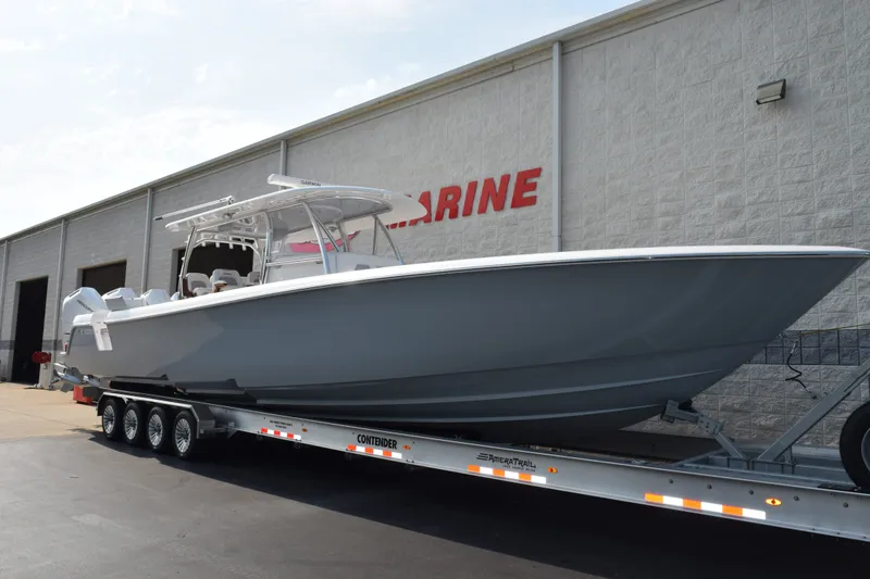 Slide: The Image of 2027 Contender 44 ST boat on trailer outside marine facility. - 2